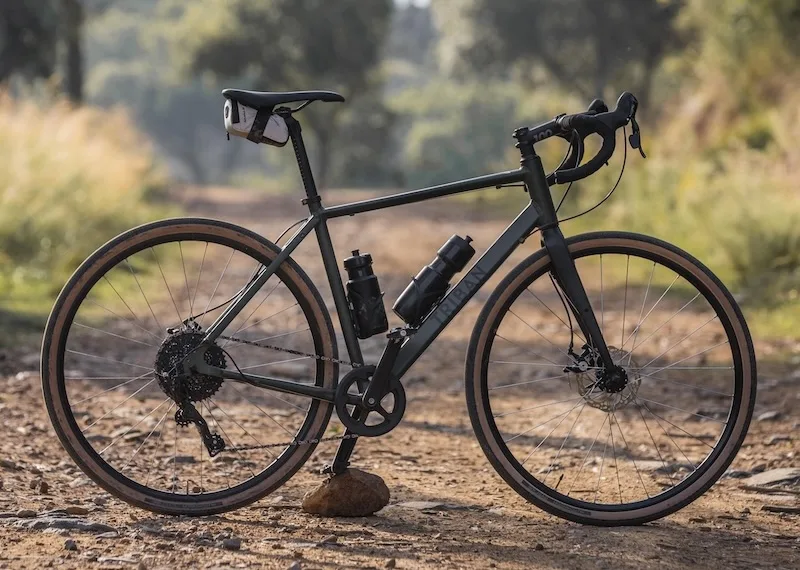 Sideways view of Triban 120 Gravel Bike outdoors on path in countryside